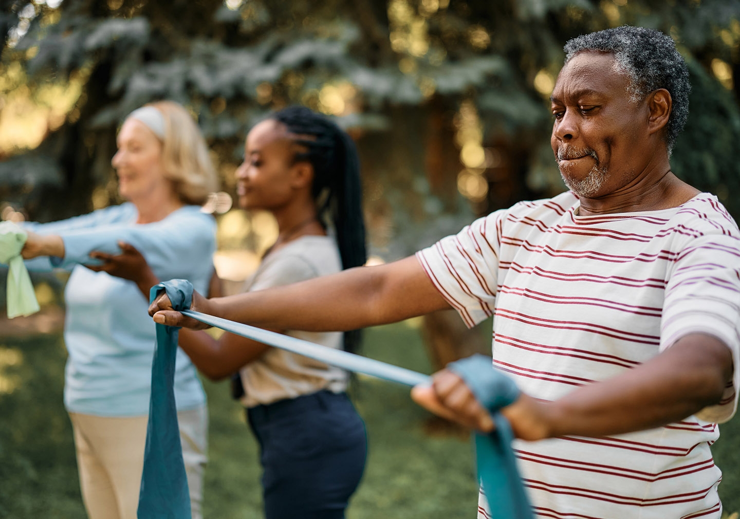 Man stretching fitness band in outdoor fitness class