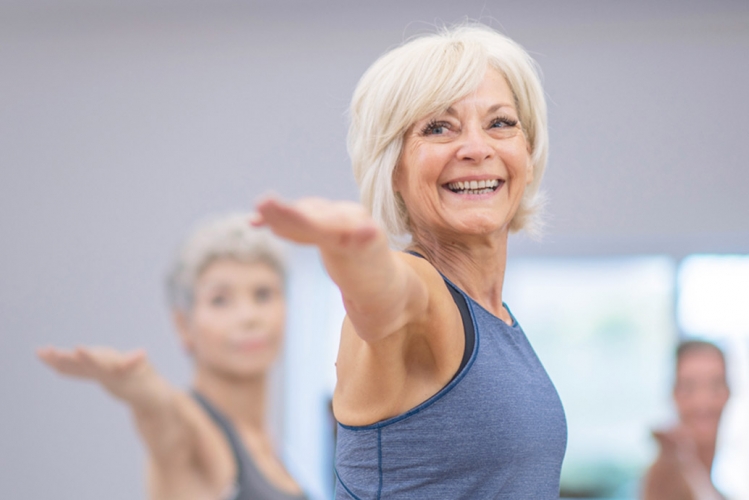 Seniors stretching in a gym in a fitness class