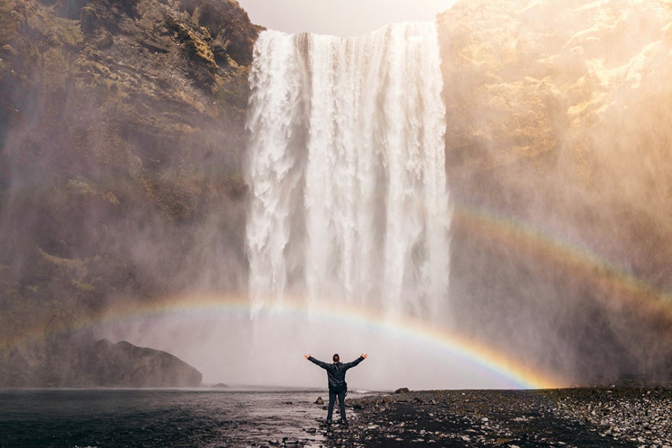 Person looking at a waterfall with rainbows