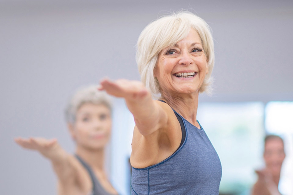 Seniors stretching in a fitness class at a gym